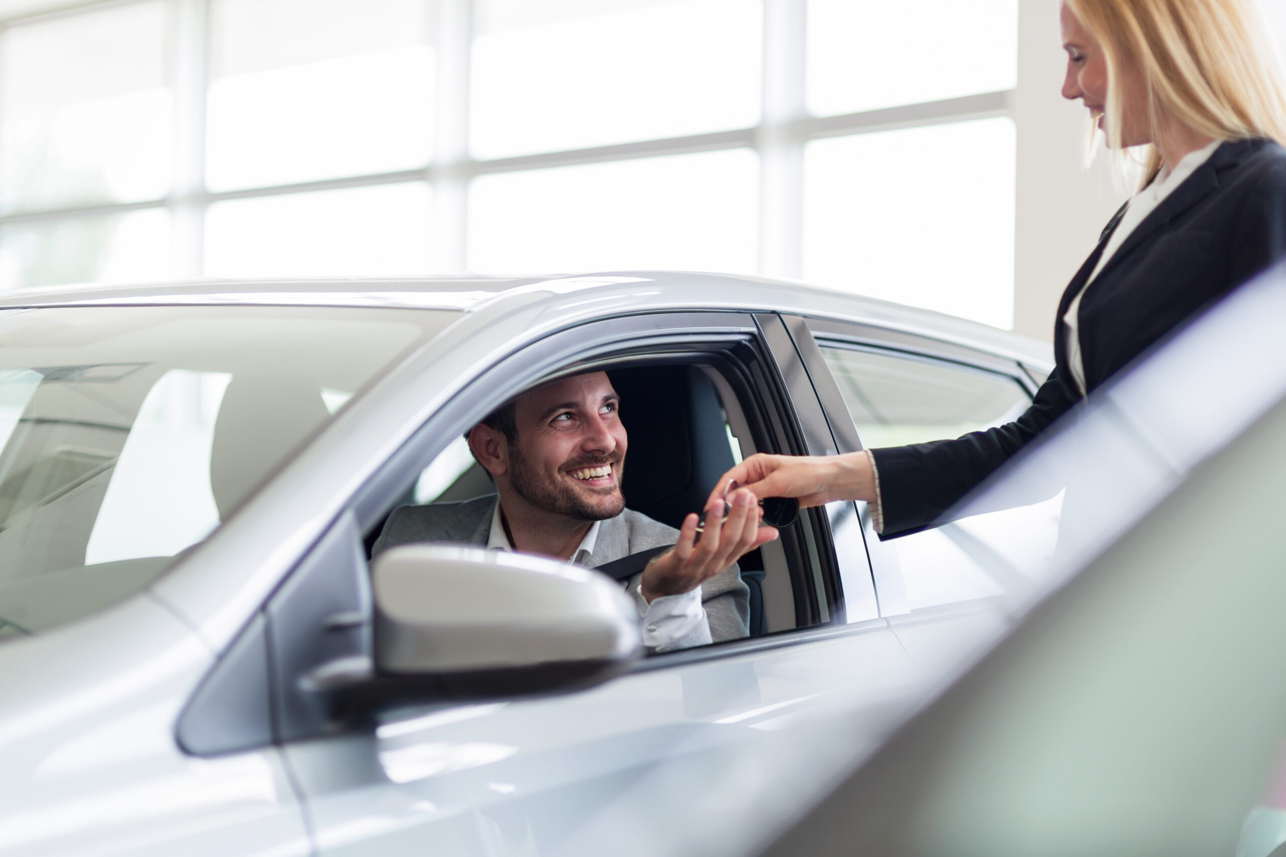 happy customer getting key to new leased car