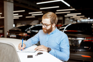 Man buying a new car at the dealership